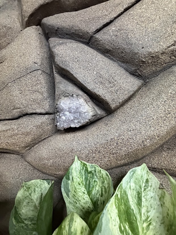 Crystal nestled between sculpted stone-like surfaces