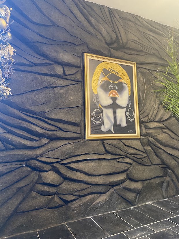 Textured interior wall with organic stone-like relief and a framed painting