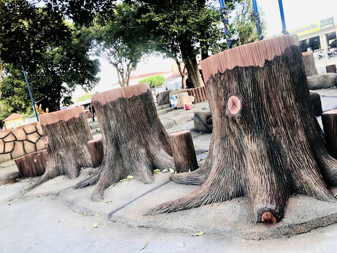 Three large planters shaped as tree trunks with spreading roots